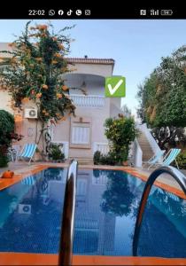 a picture of a swimming pool in front of a house at Maisons Maktoub Djerba in Al Maqārisah