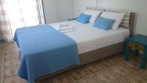 sypialnia z dużym łóżkiem z niebieskimi poduszkami w obiekcie 9 Muses w Elafónisos