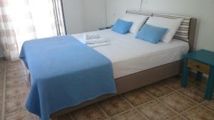 a bedroom with a large bed with blue pillows at 9 Muses in Elafonisos