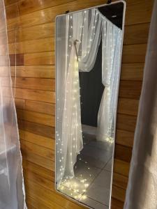 a mirror with a window with a curtain and lights at Refugio Viggena in Tandil +22 photos