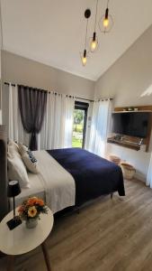 a bedroom with a large bed and a table with flowers on it at Villa Pomerode Hospedagem - Suítes com conforto e aconchego conectados com a Natureza in Pomerode