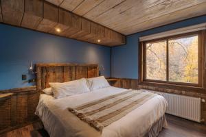 a bedroom with a large bed in a blue room at VT Coffee & Lodge in Curarrehue