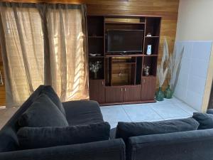 a living room with a couch and a flat screen tv at Refugio Viggena in Tandil