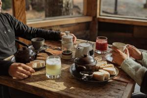 a group of people sitting at a table with food at VT Coffee & Lodge in Curarrehue +13 photos