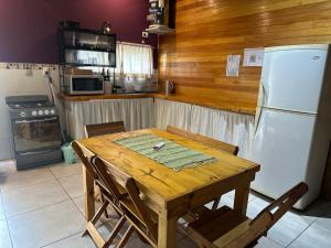 a kitchen with a wooden table and a white refrigerator at Refugio Viggena in Tandil