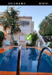 a picture of a swimming pool in front of a house at Maisons Maktoub Djerba in Al Maqārisah