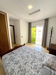a bedroom with a bed and a large window at Visit Chamal - Palmera 4 in Oued Laou