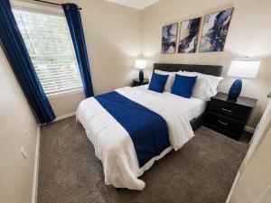 a bedroom with a large bed with blue pillows at Spacious 3BR Retreat Perfect for Groups Near Downtown in Raleigh
