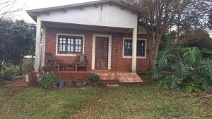 a small house with a porch and a bench in the yard at Vivienda Wagner in Dos de Mayo