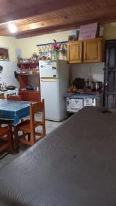 a kitchen with a table and a white refrigerator at Vivienda Wagner in Dos de Mayo