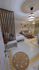 a living room with a bed and a couch at Le Nid Créole in Belle-Allée