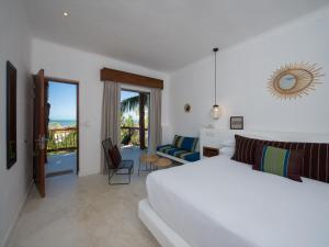a white bedroom with a bed and a balcony at Villas HM Palapas del Mar in Holbox Island