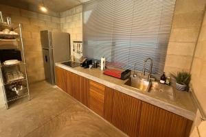 a kitchen with a sink and a refrigerator at Santas y Santos in Todos Santos