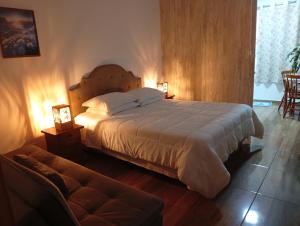 a bedroom with a large bed and a couch at Hospedaria Mitterer in Treze Tílias