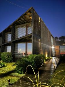a house with a wooden walkway in front of it at CASA NEGRA SANTO DOMINGO in Santo Domingo