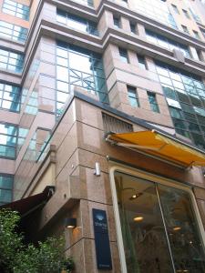 a tall building with a restaurant in front of it at Shama Central in Hong Kong