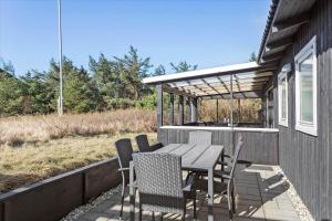 a patio with a table and chairs on a deck at 828-Thisted-Orredvej-13 in Thisted