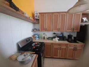 a kitchen with wooden cabinets and a stove top oven at hebergement paradis Haiti in Petionville