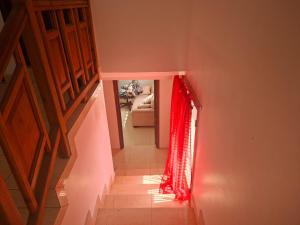 a hallway with a red curtain and a stairway at hebergement paradis Haiti in Petionville