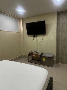 a bedroom with a bed and a flat screen tv at La Rosita 2 in Puerto Colombia +3 photos
