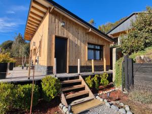 a small wooden house with a porch and stairs at Cabañas Dos Maitenes in Villa Traful