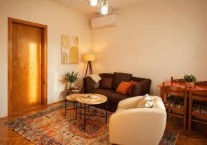 a living room with a couch and a table at Green Cottage in Podgorica +12 photos