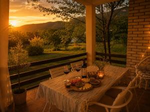 a table with a plate of food and a bottle of wine at Green Cottage in Podgorica