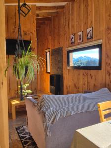 a bedroom with a bed in a wooden wall at Cabañas Dos Maitenes in Villa Traful