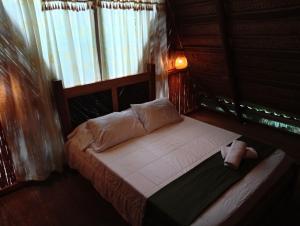 a small bed in a room with a window at A-típico in Santa Marta