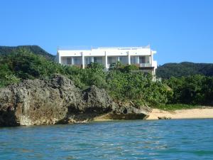 a house on a cliff next to the water at Seven Colors Ishigakijima in Ishigaki Island