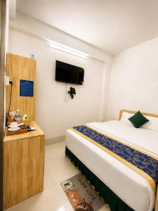 a hotel room with a bed and a flat screen tv at Khách Sạn The Second in Thốt Nốt