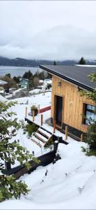 a log cabin in the snow with the door open at Cabañas Dos Maitenes in Villa Traful +21 photos
