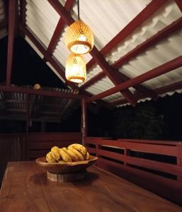 a bowl of bananas on a table with a chandelier at A-típico in Santa Marta