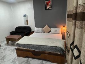 una piccola camera da letto con un letto e una sedia di Hotel Caledonian a Chantan