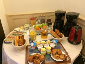 una mesa con una bandeja de donuts y otros productos de desayuno en Hotel Acapulco, en Montpellier