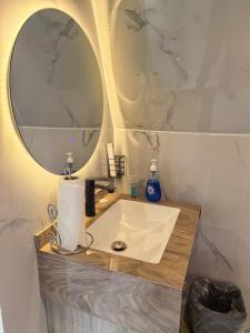 a bathroom with a sink and a large mirror at سكوْن in Al Baha
