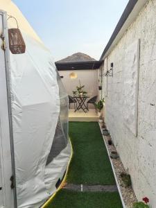a small courtyard with green grass and a tent at سكوْن in Al Baha