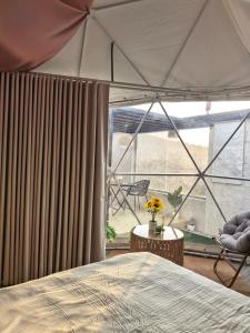 a bedroom with a bed and a large window at سكوْن in Al Baha