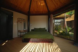 a bedroom with a green bed and a large window at Nọng Villa in Phan Thiet +132 photos