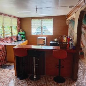 a kitchen with a counter and two bar stools at Pelly Homestay Adventure in Taveuni