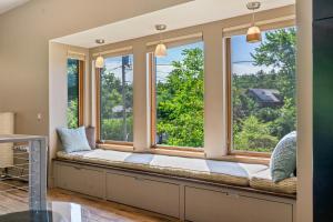 a window seat in a room with two windows at The Crag On the Acadia National Park Border - Deck, Fire Pit, Steps to Trails in Otter Creek