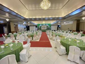 a banquet hall with green and white tables and chairs at A&A Plaza Hotel in Puerto Princesa City