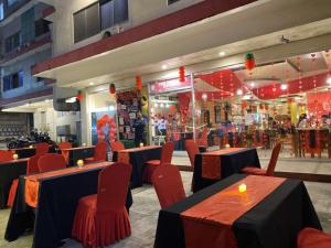 a restaurant with tables and red chairs and a store at A&A Plaza Hotel in Puerto Princesa City