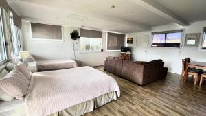 a bedroom with a bed and a couch and a table at Frangipani Cottage in Wooli +11 photos