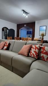 a living room with a gray couch with red and white pillows at Chácara Monteiro - Próximo ao Thermas Water Park in São Pedro