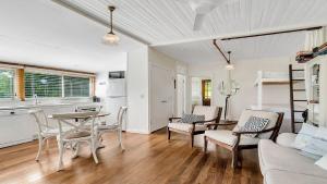 a kitchen and living room with a table and chairs at Tullenderly in Wooli