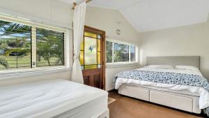 a bedroom with two beds and a window at Tullenderly in Wooli +11 photos