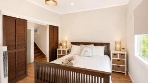 a bedroom with a large white bed and wooden floors at Surfside in Wooli +7 photos