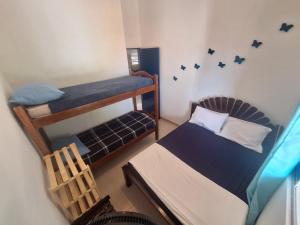 a bedroom with two bunk beds and a chair at Chalet da Bela Vista in Itamaracá