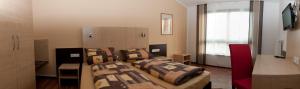 ein Zimmer mit 2 Betten und einem Sofa darin in der Unterkunft Auszeit Cafè & Hotel in Oberwörnitz